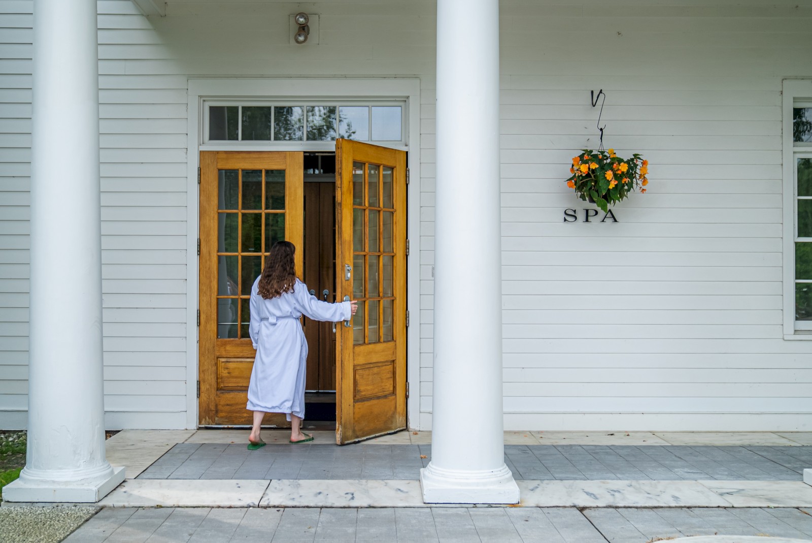A person in a robe enters a building labeled 
