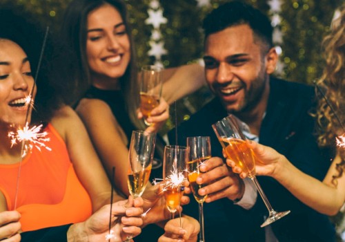 A group of people celebrating with sparklers and champagne glasses, smiling and enjoying a festive atmosphere.