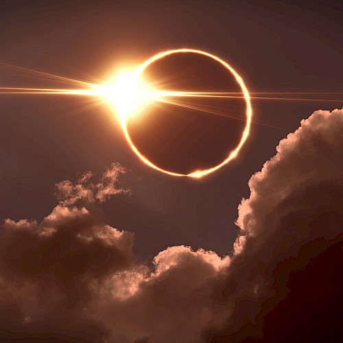 A solar eclipse with the sun shining from behind the moon, forming a bright ring of light, partially obscured by clouds.