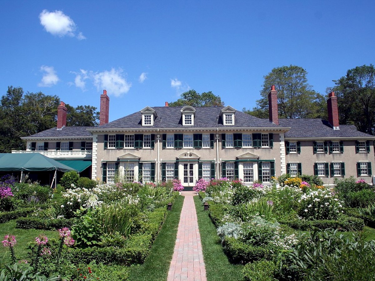 Exterior image of the Hildene Estate on a Sunny day. Surrounded by a manicured lawn and flowers in the spring.